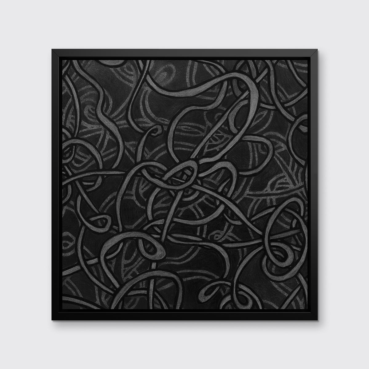 A black and dark grey abstract print in a black floater frame hangs on a white wall.