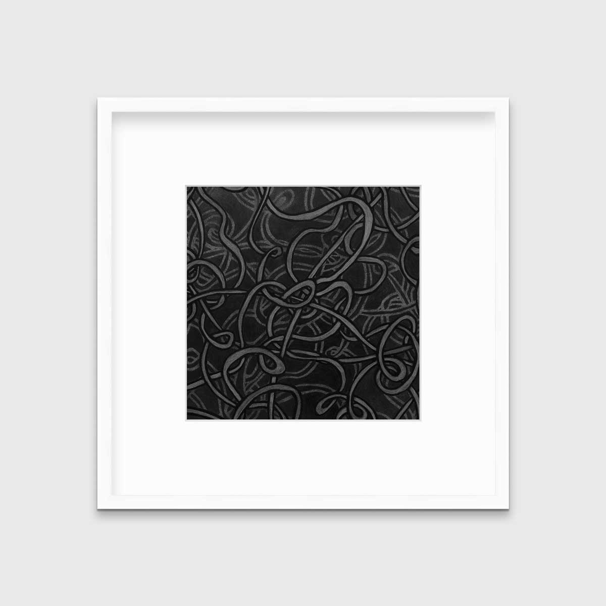 A black and grey abstract print in a white frame with a mat hangs on a white wall.