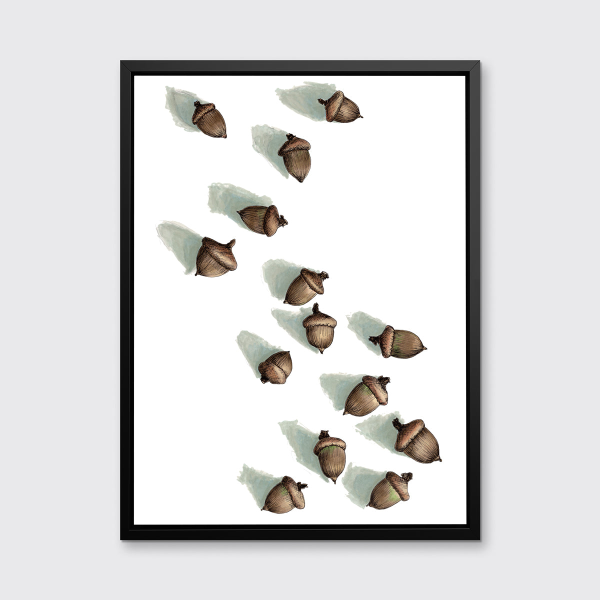 A print of several brown acorns with long shadows on a white background in a black floater frame hang on a white wall.