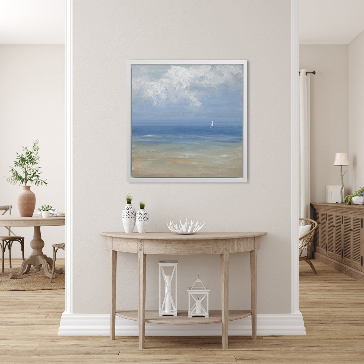 A blue, light green, beige and white abstract seascape print with a small sailboat in a white floater frame hangs on a white wall.