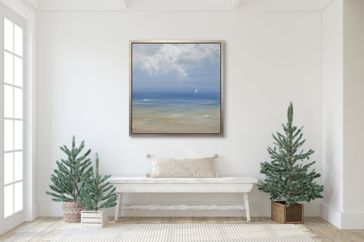 A blue, light green, beige and white abstract seascape print with a small sailboat in a silver floater frame hangs on a white wall above a whitewashed wood bench with a white lumbar pillow and various potted trees.