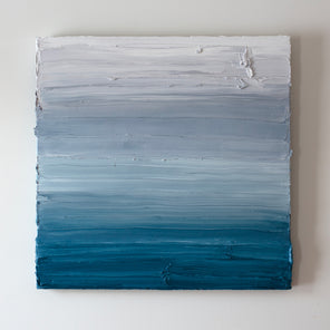 A white, light grey and tonal blues abstract painting by Teodora Guererra hangs on a white wall.