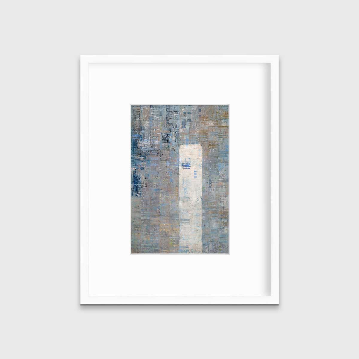 A blue and grey abstract geometric print in a white frame with a mat hangs on a white wall.