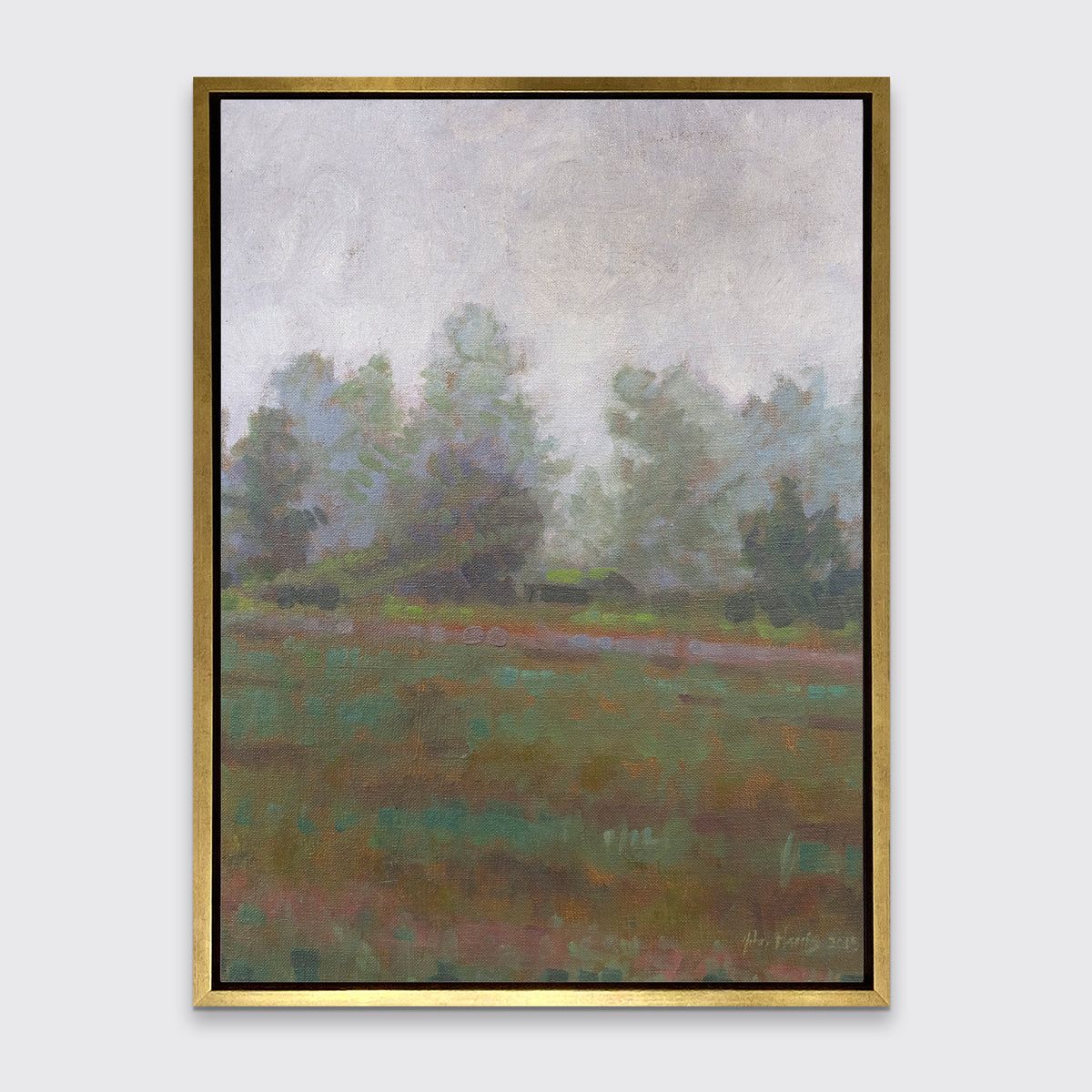 A grey and muted green abstract landscape print in a gold floater frame hangs on a white wall.