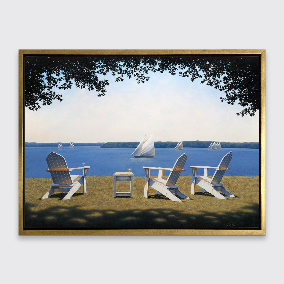 A realistic seascape with adirondack chairs print in a gold floater frame hangs on a white wall.