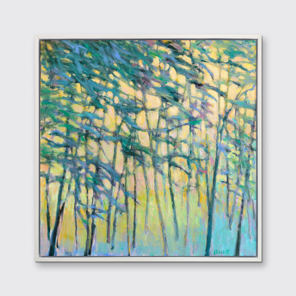 A yellow, green and blue abstract tree landscape print in a white floater frame hangs on a white wall.