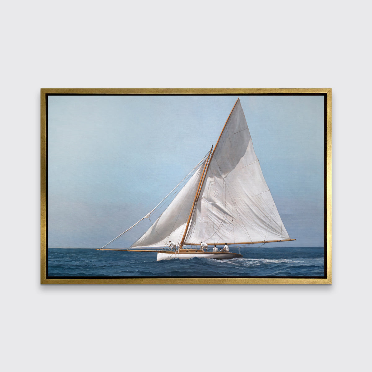 A blue, white and tan contemporary seascape print with a sailboat in a gold floater frame hangs on a white wall.
