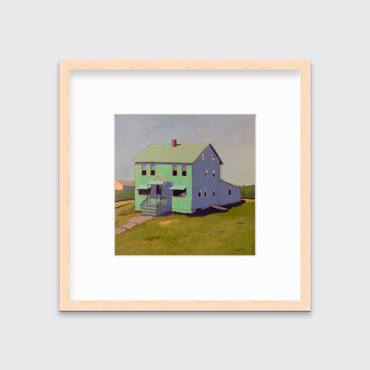 A seafoam green, blue and chartruse contemporary house print in a natural wood frame with a mat hangs on a white wall.