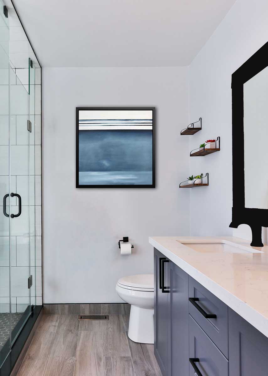 Abstract painting of blue and white horizontal lines in a black floater frame hanging on a white wall next to a glass shower. 