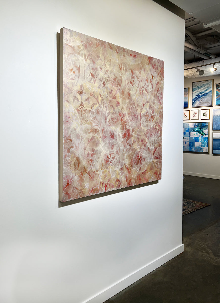 A left side-angle view of a coral, beige and gold-leaf abstract painting by Roger Mudre hangs on a white wall.