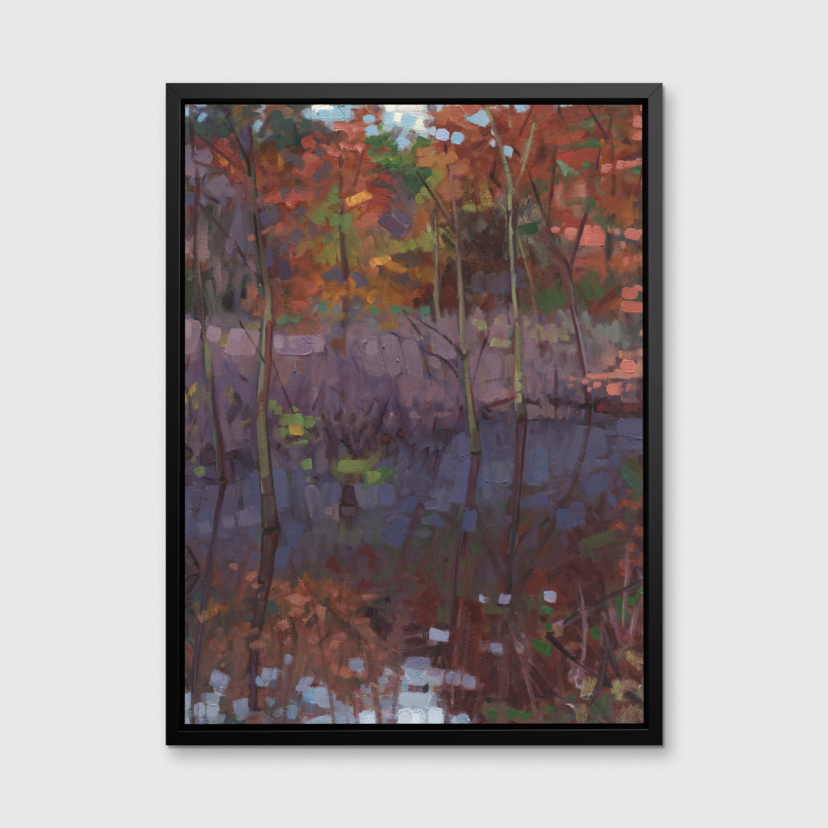 A muted multicolored abstract landscape print in a black floater frame hangs on a white wall.