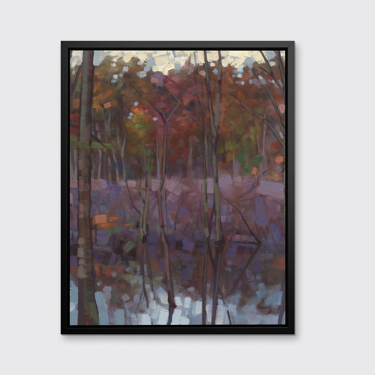 A muted multicolored abstract landscape print in a black floater frame hangs on a white wall.