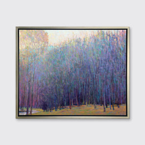 A blue and purple abstract tree landscape print in a silver floater frame hangs on a white wall.