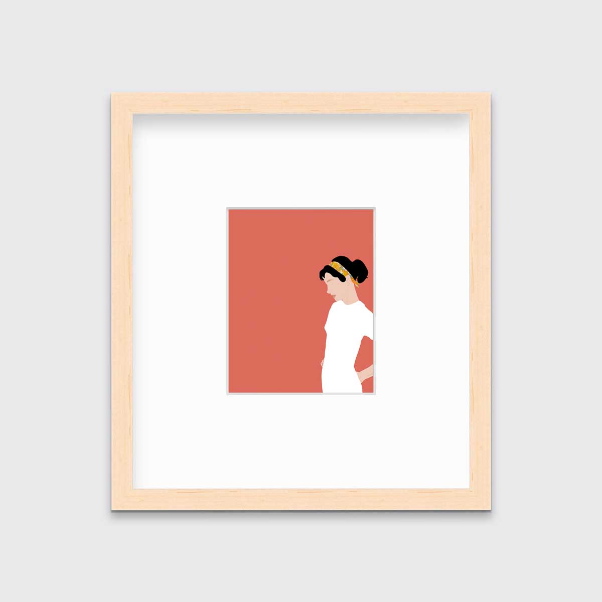 A print with a woman in a white dress and pink background, framed in a natural wood frame on a grey wall.