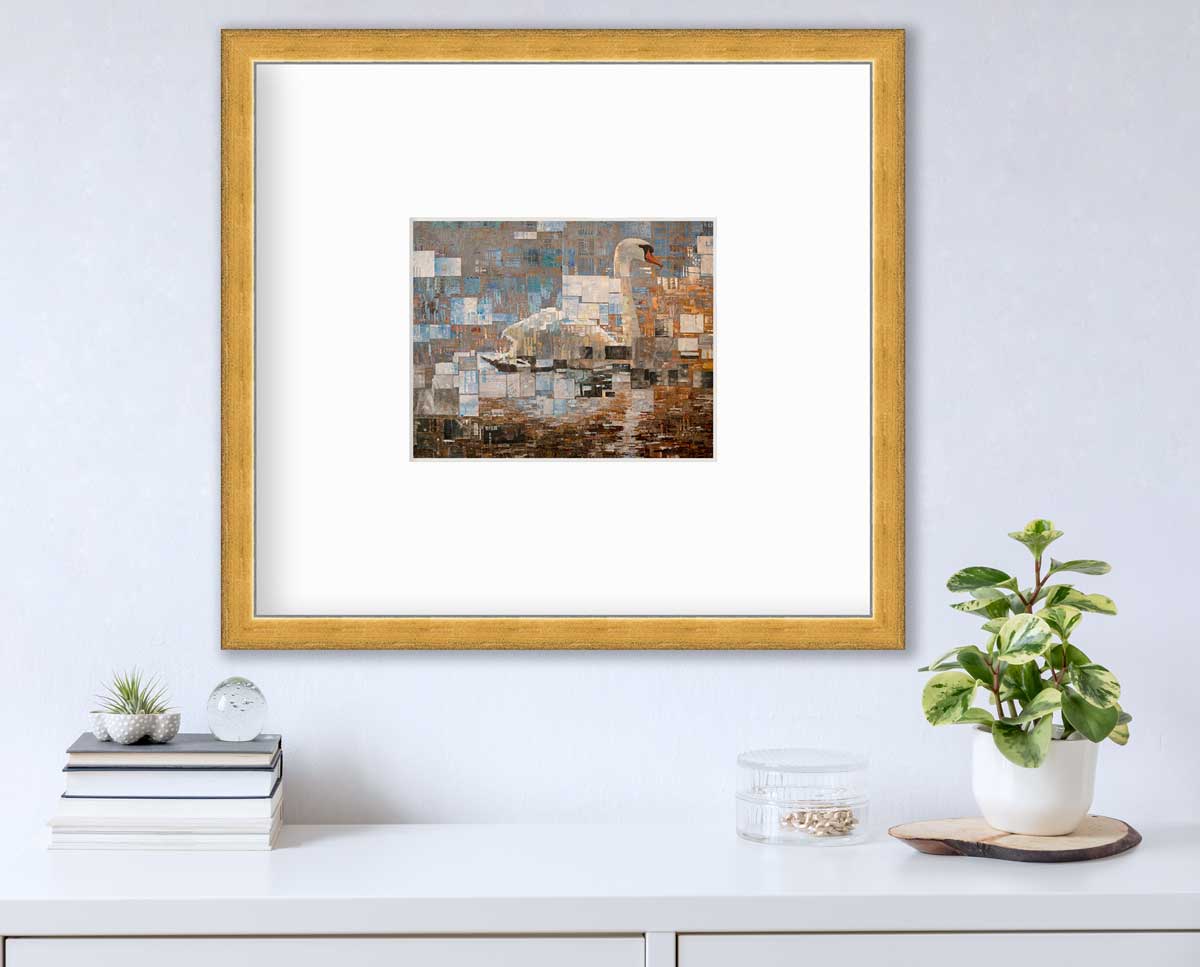 A grey, white and burnt orange abstract geometric print of a swan in a gold frame with a mat hangs on a white wall above a white surface with a stack of books, a clear round container with gold accessories and a potted plant.