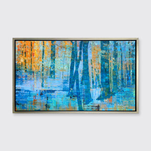 A blue, green and orange abstract tree landscape print in a silver floater frame hangs on a white wall.
