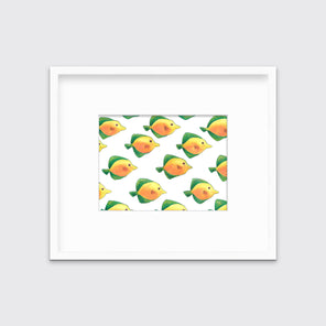 A print of orange and yellow fishes with green fins in a white frame with a mat hangs on a white wall. 
