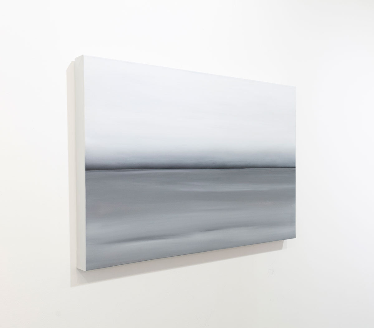 A grey oil painting with a single black line in the middle of the painting that suggests a horizon line is seen at an angle on a gallery wall. Wired and ready to hang.