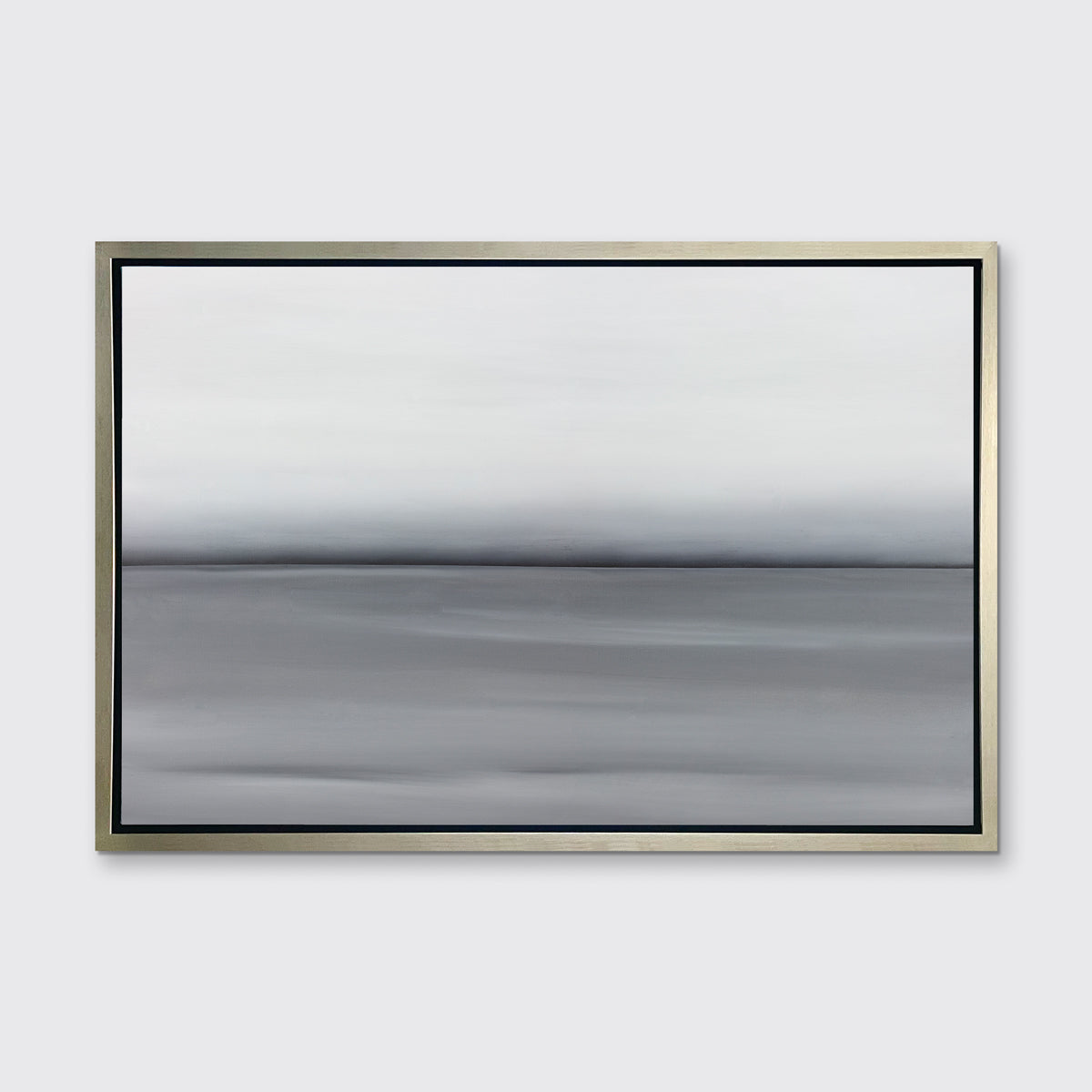 A grey toned abstract landscape print in a silver floater frame hangs on a white wall.