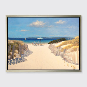 A realistic seascape print in a silver floater frame hangs on a white wall.
