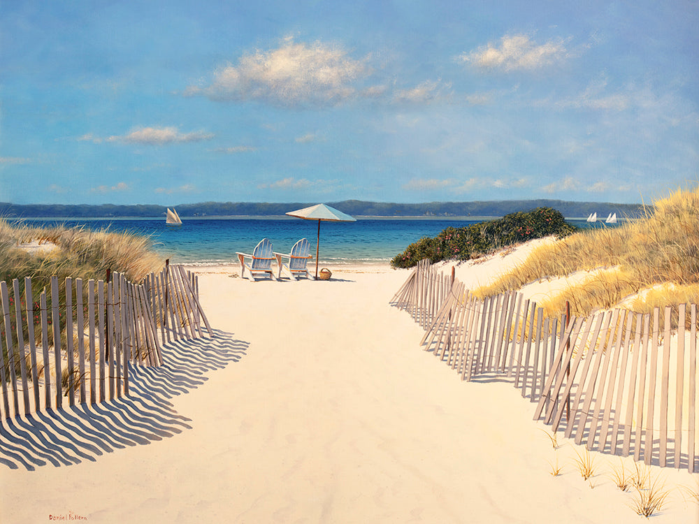 A print of a small path between two dunes that leads to a small piece of beach. In the distance you can see a few sail boats out for the day. One the edge of the water are two beach chairs set up with an umbrella and a smal basket. 