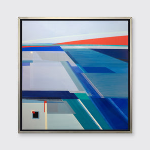 A blue, teal, and orange geometric print in a silver floater frame hangs on a white wall.
