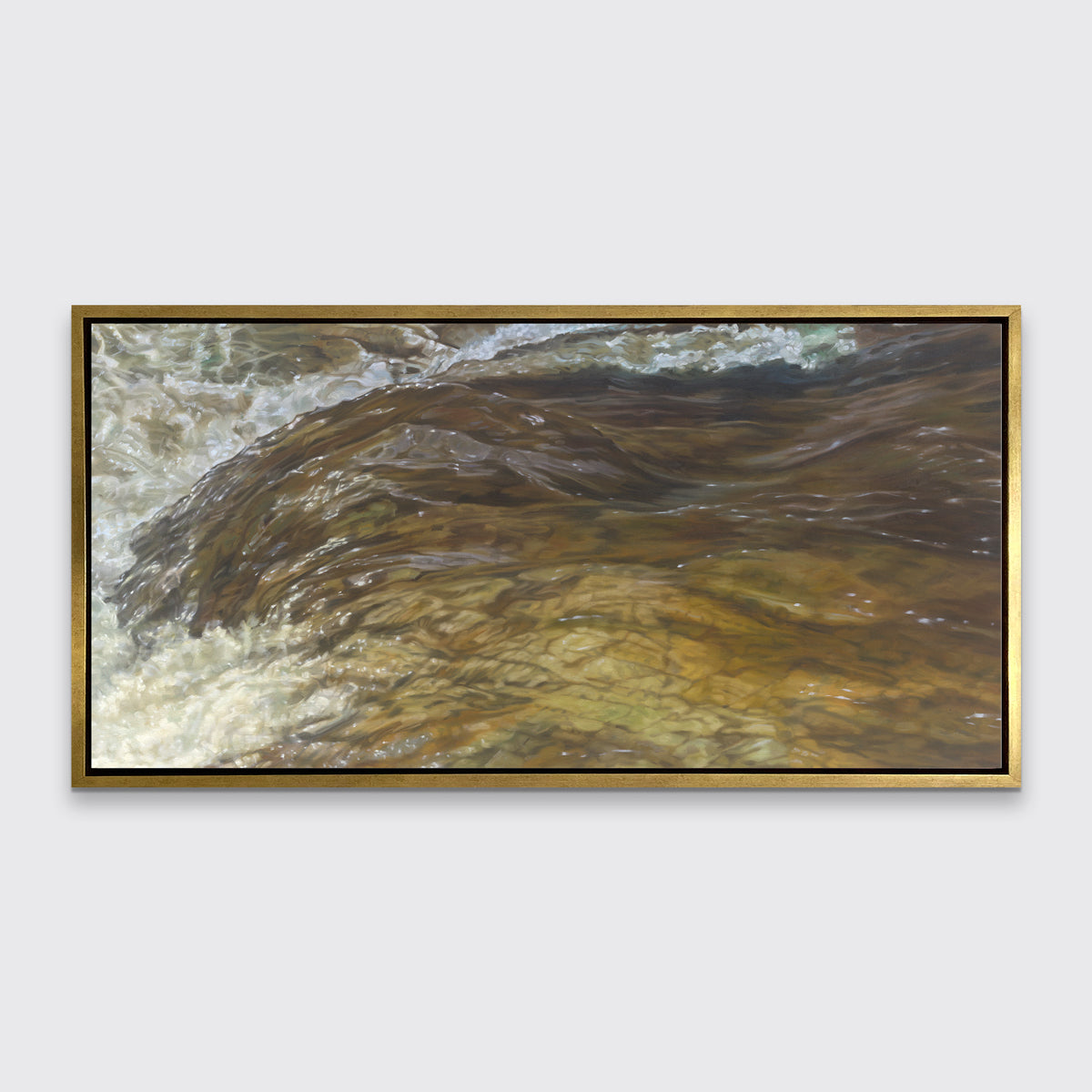 A brown, beige and white abstract river print in a gold floater frame hangs on a white wall.