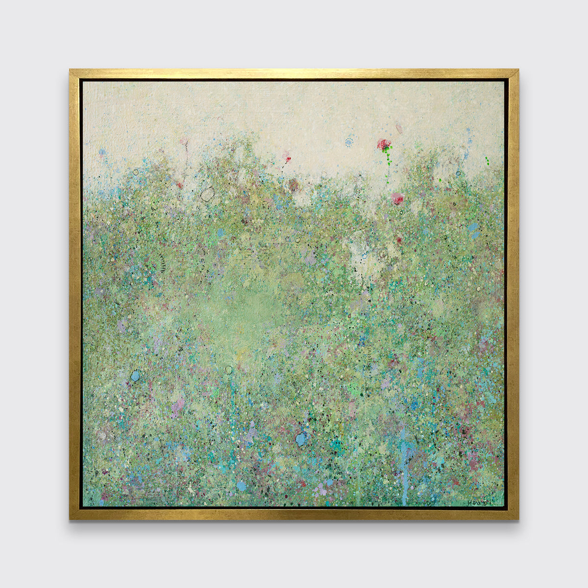 A green and light yellow abstract landscape print in a gold floater frame hangs on a white wall.