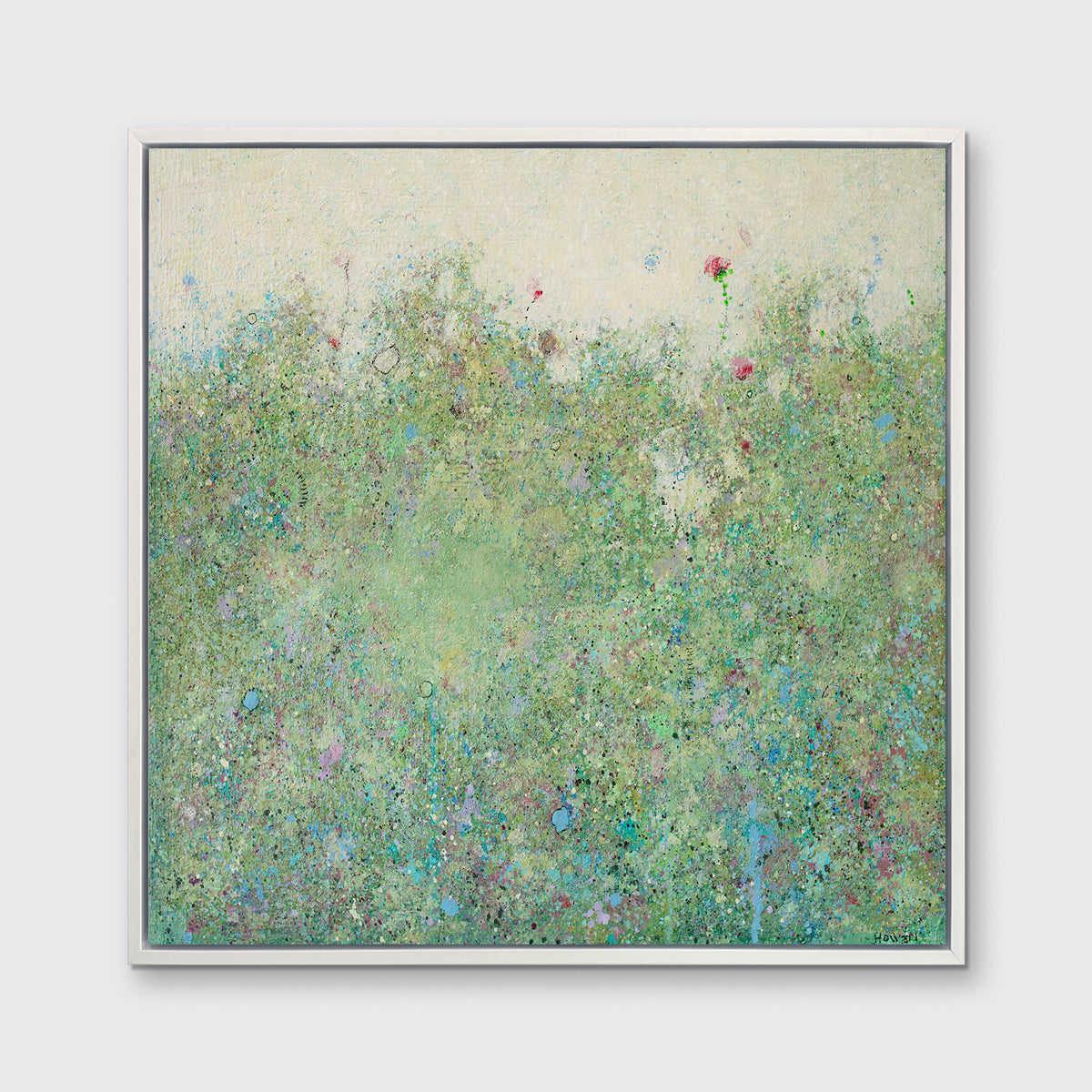 A green and light yellow abstract landscape print in a white floater frame hangs on a white wall.