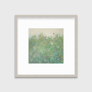 A green abstract landscape print in a silver frame with a mat hangs on a white wall.