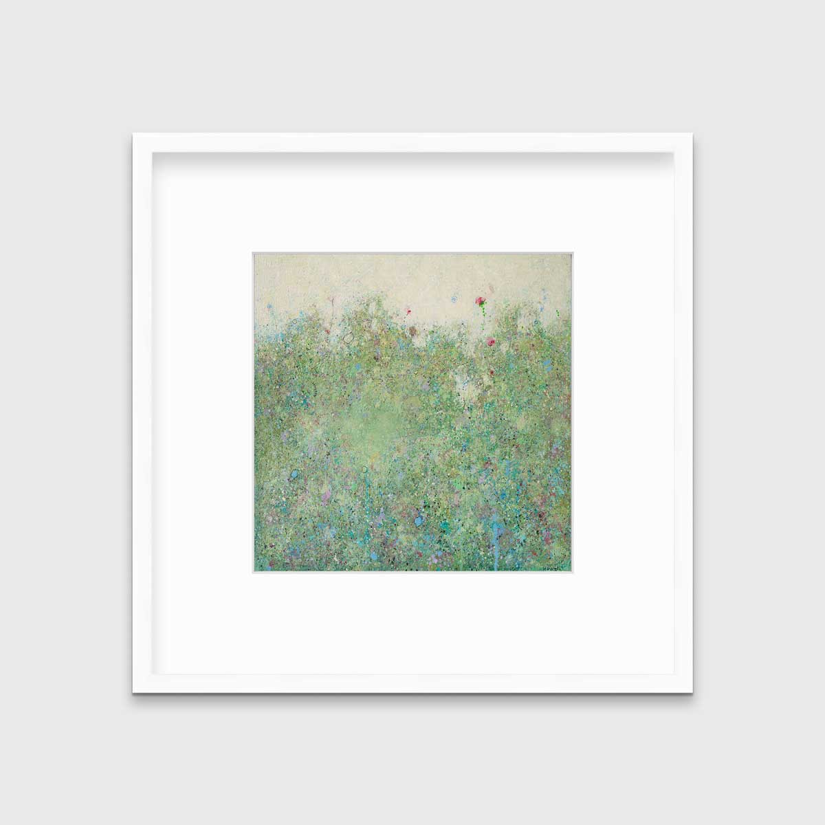 A green abstract landscape print in a white frame with a mat hangs on a white wall.