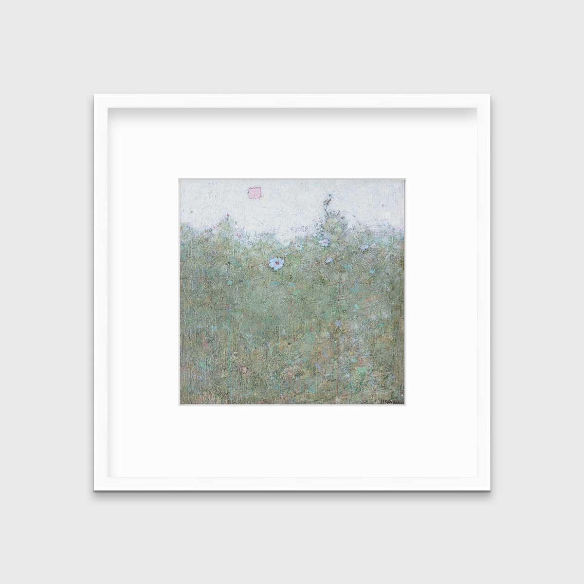 A green and blue abstract landscape print in a white frame with a mat hangs on a white wall.