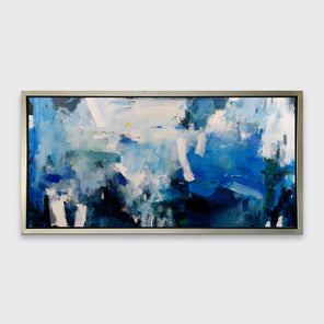 A blue, white and black abstract print in a silver floater frame hangs on a white wall.