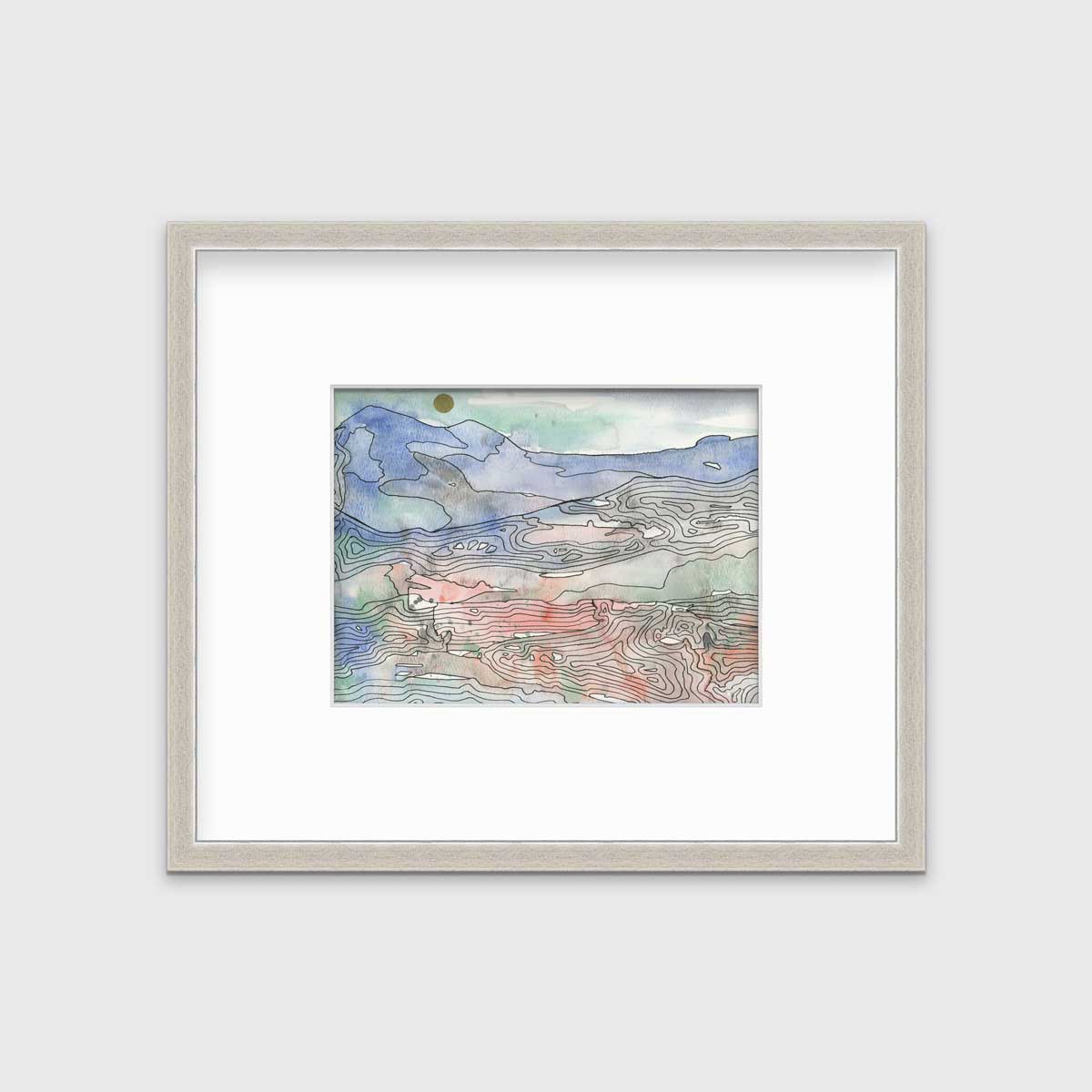 A blue, green and red abstract landscape print in a silver frame with a mat hangs on a white wall.