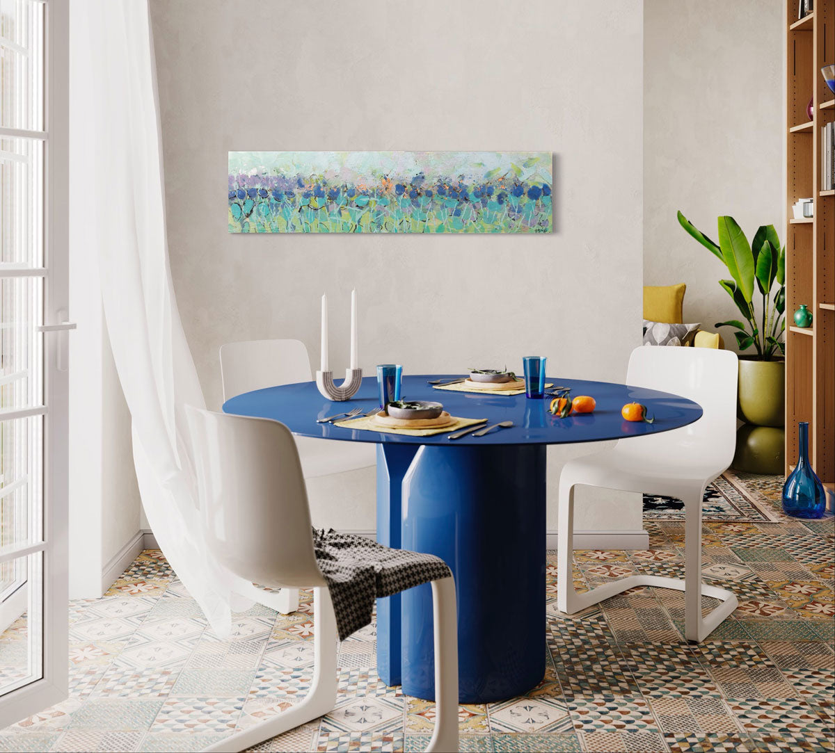 A wooden panel decorated in blue and cyan encaustic markings is hung near a blue dining table.