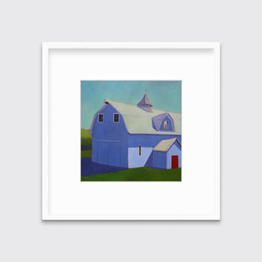 A light blue, lavender and beige contemporary barn print in a white frame with a mat hangs on a white wall.
