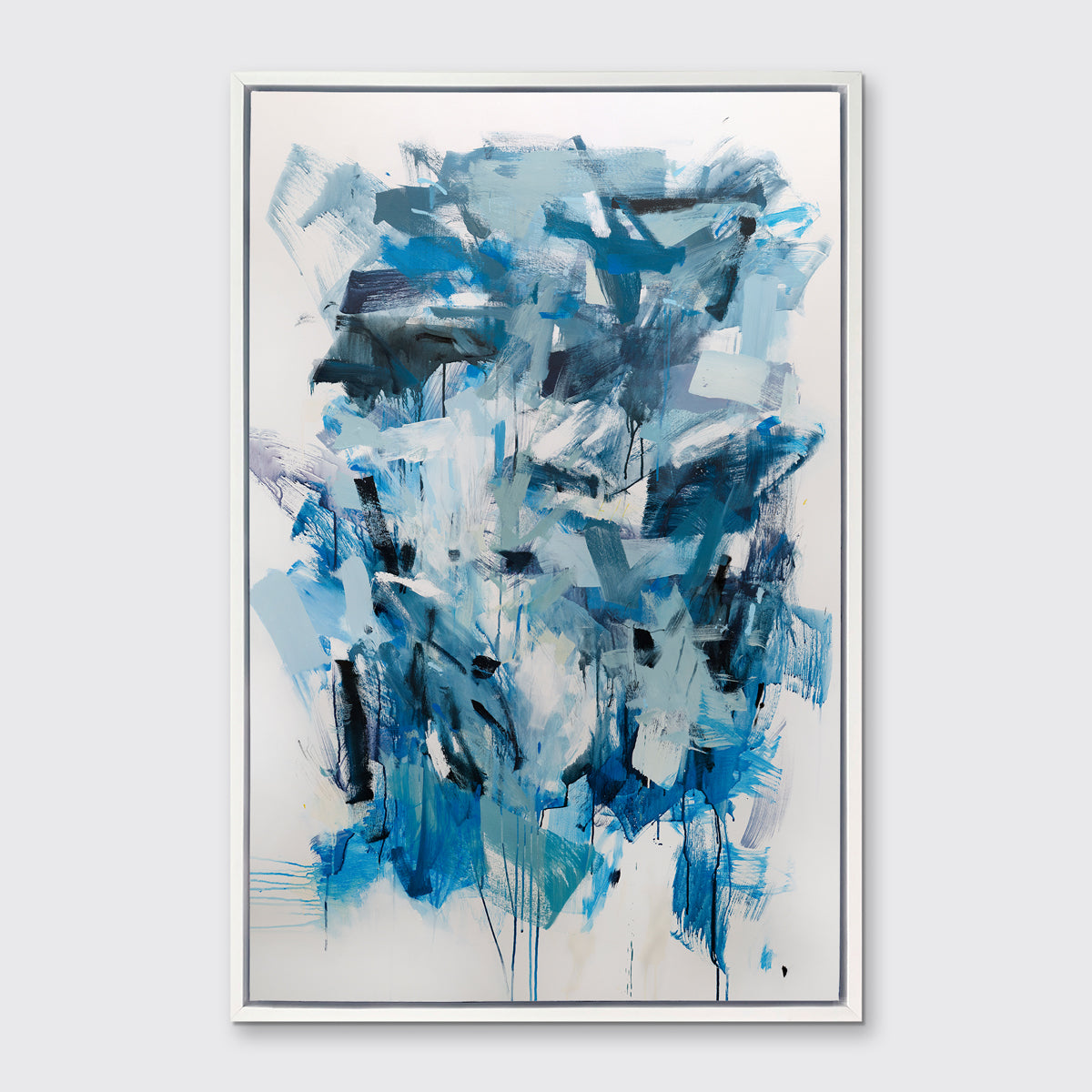 A blue, teal and white abstract print in a white floater frame hangs on a white wall.