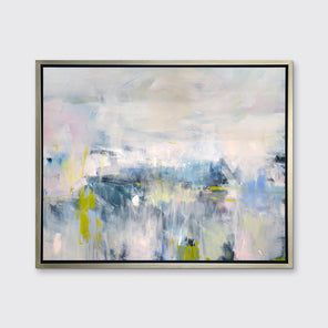A pale pink, blue and white abstract print in a silver floater frame hangs on a white wall.