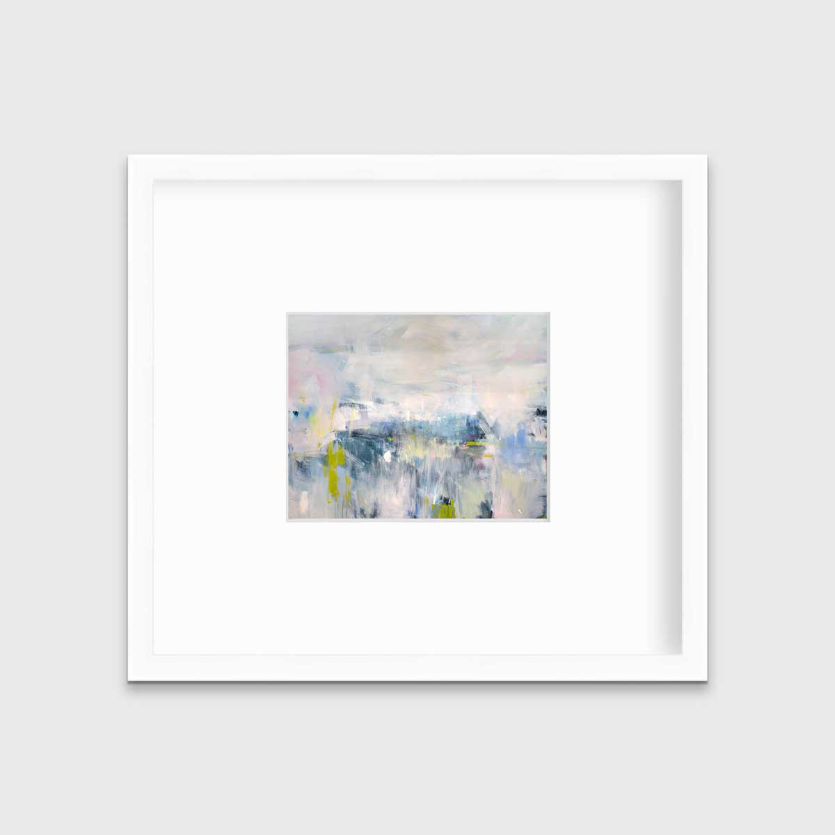 A pink and blue abstract print in a white frame with a mat hangs on a white wall.