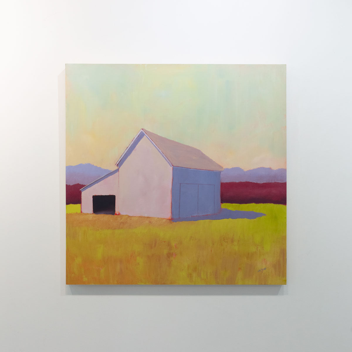 A painting of a barn on a white gallery wall. Wired and ready to hang.