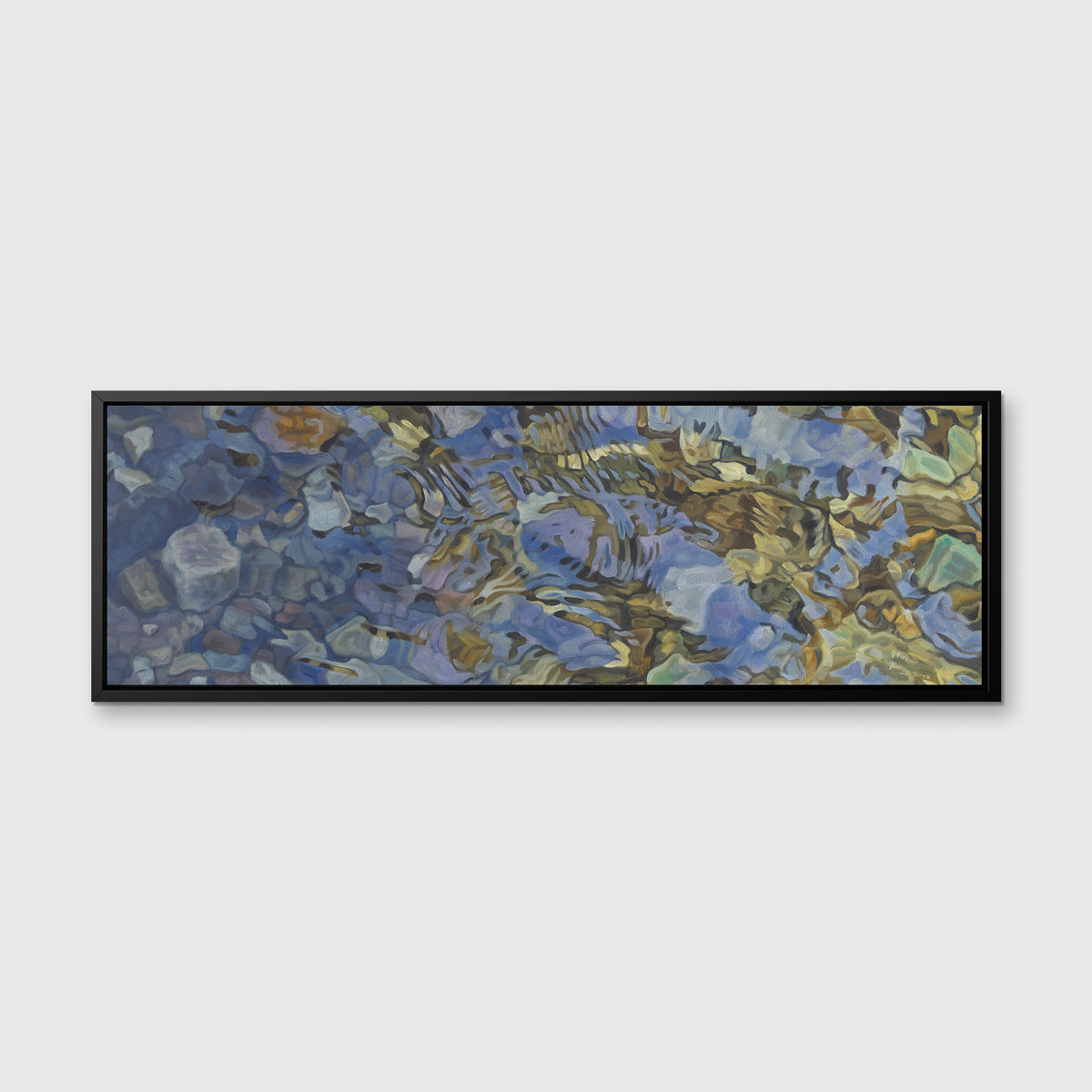 A brown, dark green, white and light blue abstract river rocks in water print in a black floater frame hangs on a white wall.