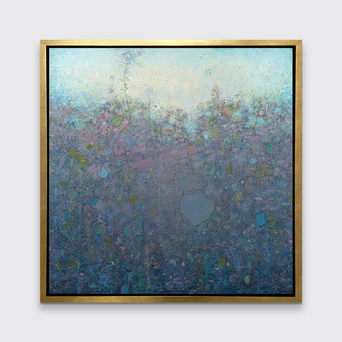 A dark purple and blue abstract landscape print in a gold floater frame hangs on a white wall.