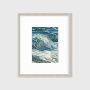 A blue, teal, white and light green abstract water wave print in a silver frame with a mat hangs on a white wall.