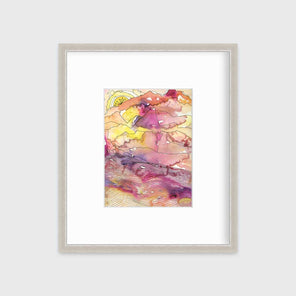 A yellow, pink, orange and black abstract landscape print in a silver frame with a mat hangs on a white wall.