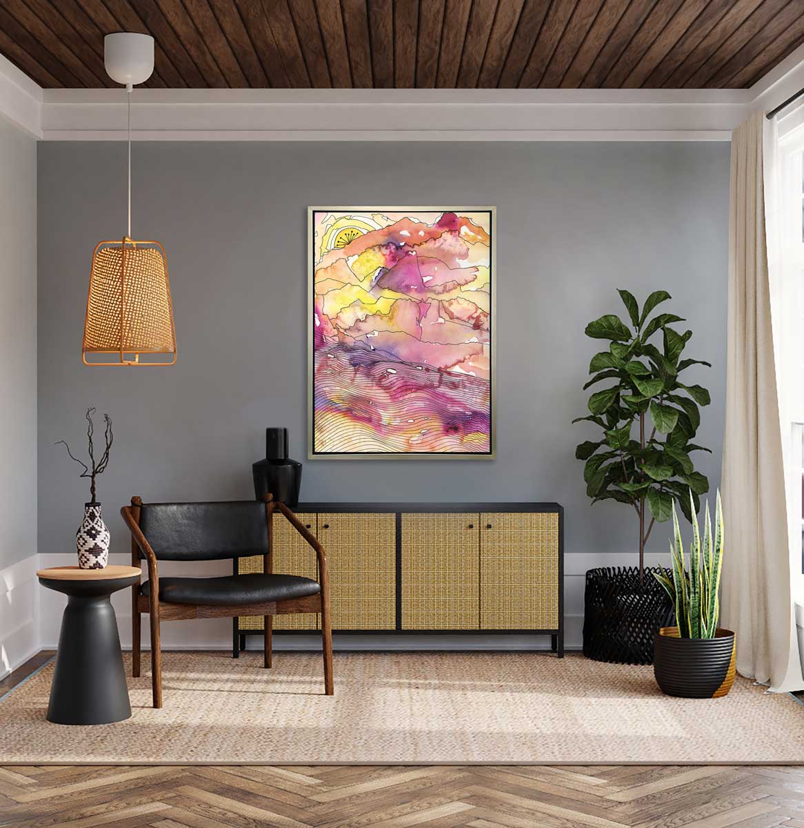 A yellow, pink, purple and black abstract landscape print in a silver floater frame hangs on a grey wall above a black and rattan cabinet with a black vase, a black and dark wood chair, two potted floor plants and a black side table with a vase.