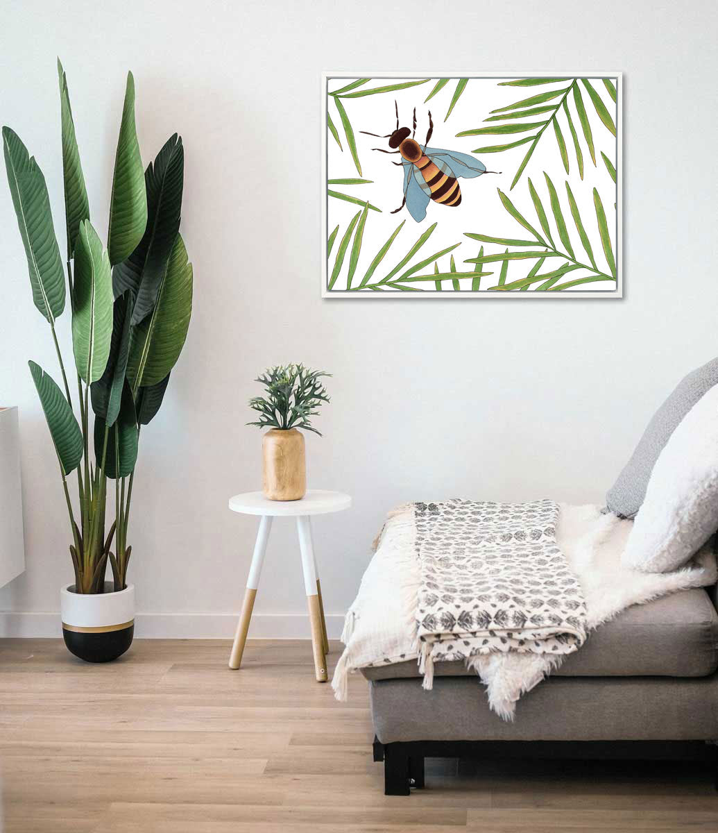 A green and white bee illustration print hangs above a grey chaise, floor plant, and a minimalist end table and vase with a plant. 