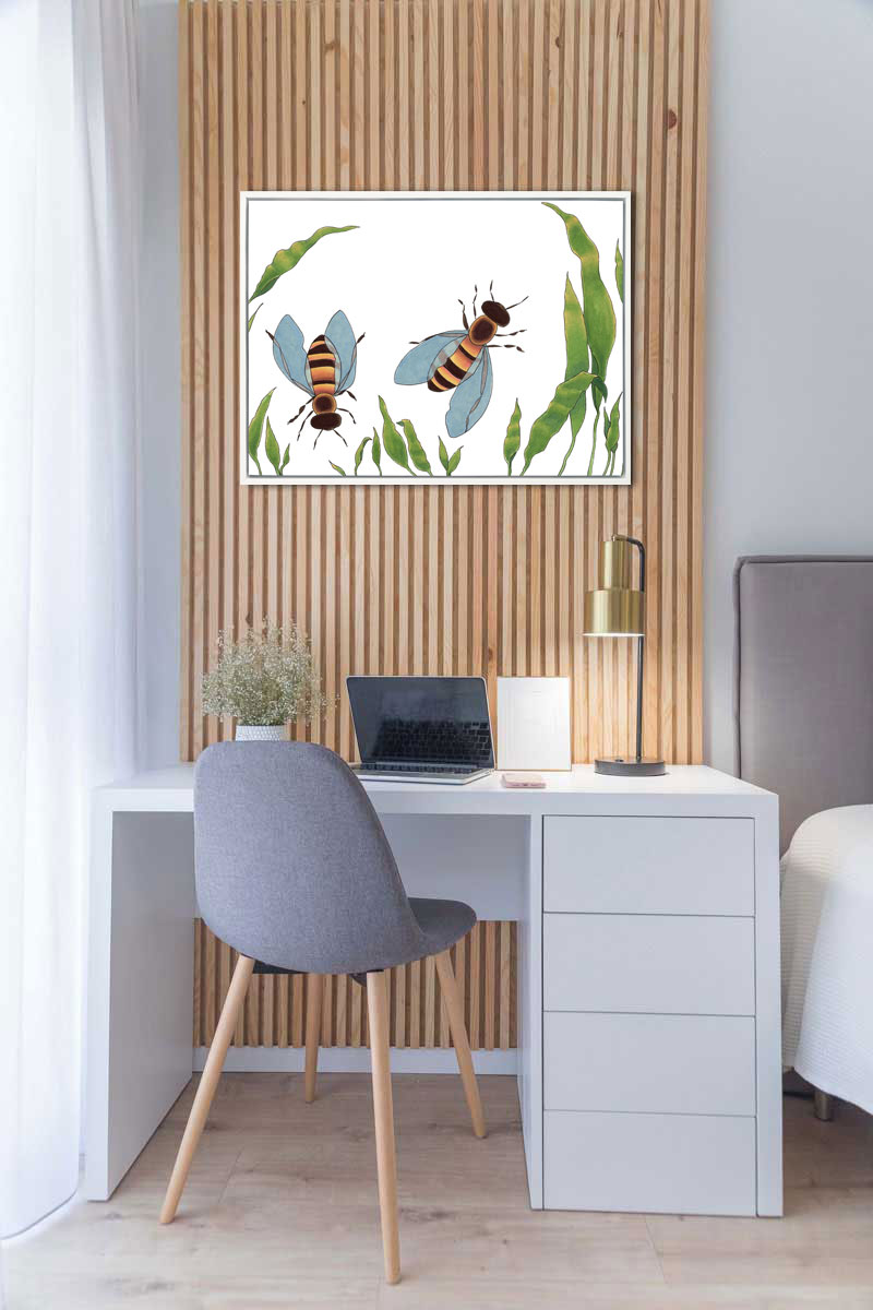 A minimalist bee illustration print hangs on a wood paneled wall above a simple white desk and grey chair. 