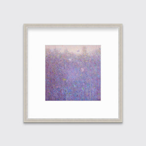 A pink abstract landscape in a silver frame with a mat hangs on a white wall.