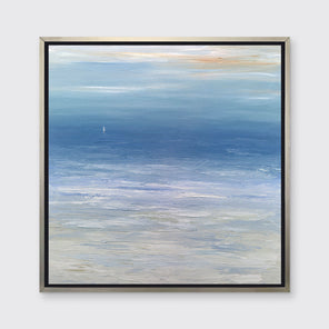 A blue, white and beige abstract seascape print in a silver floater frame hangs on a white wall.