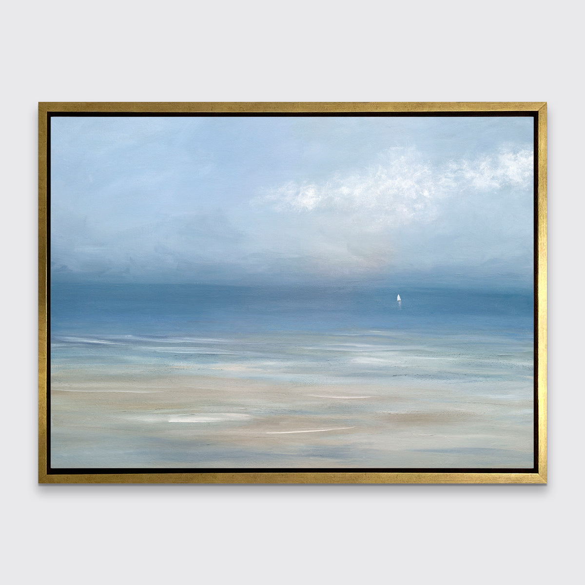 A light blue, white and beige abstract seascape print in a gold floater frame hangs on a white wall.